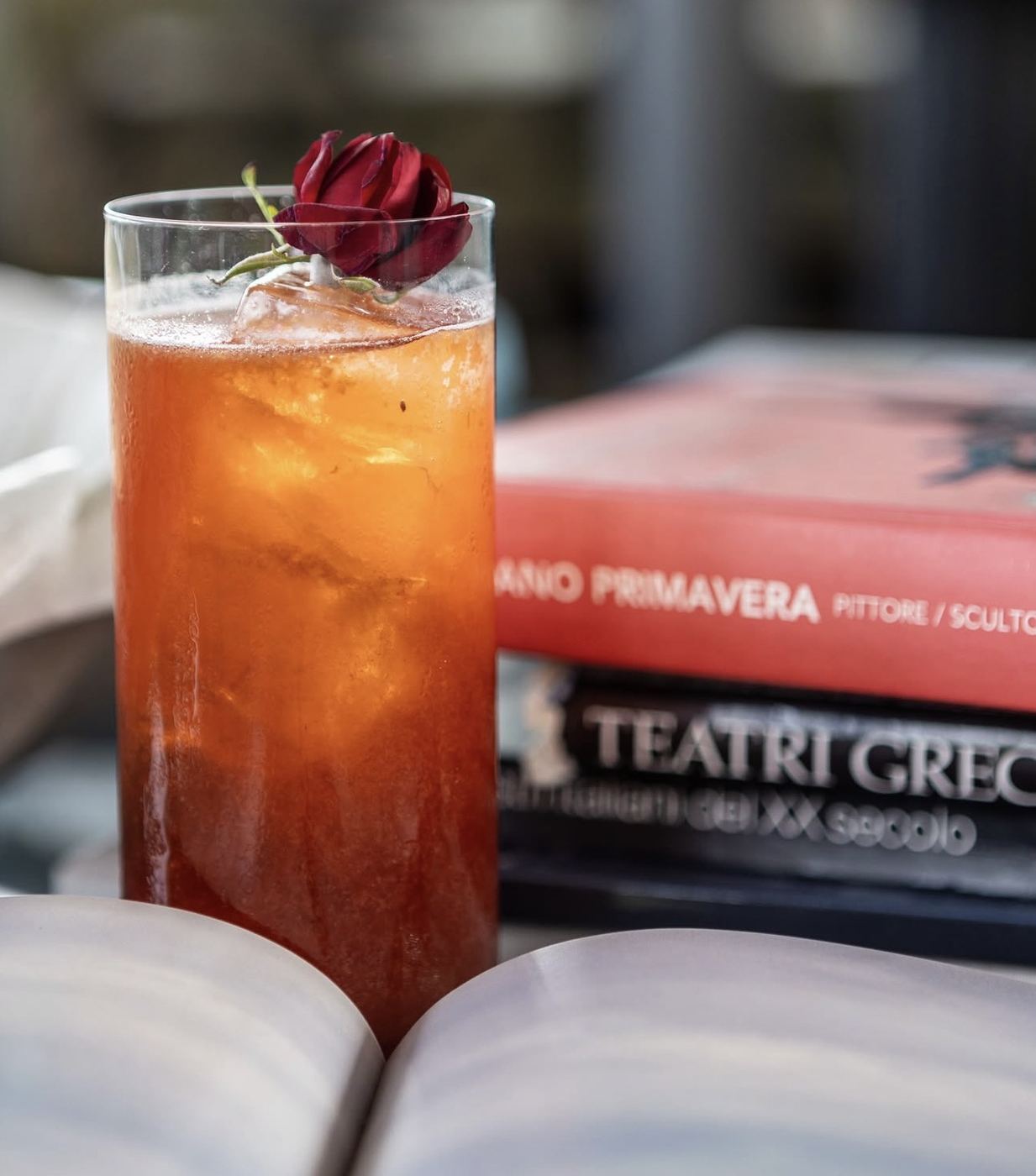 Italian cocktail beside books and an open magazine