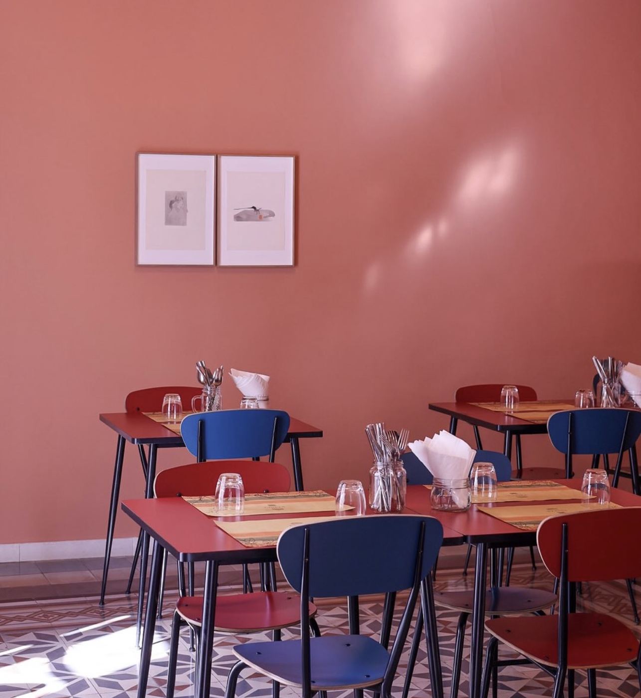 Pink restaurant interior with red and blue chairs