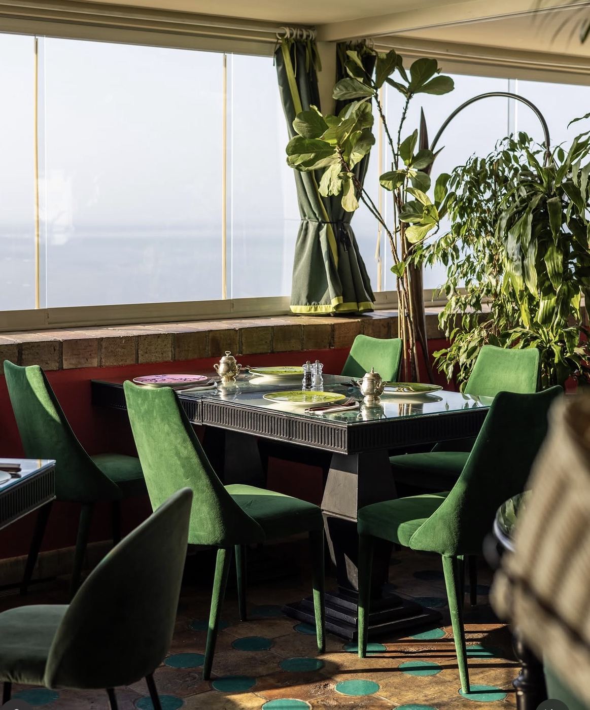 Restaurant table with green chairs and sea view